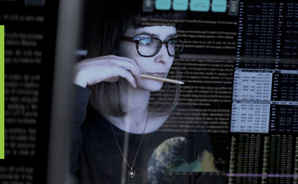 A woman holding a pencil and looking at the screen